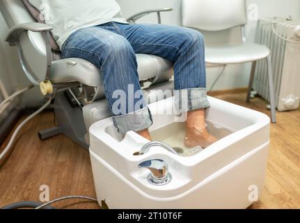 concept of male pedicure, foot pedicure, cosmetologist makes classic pedicure for an elderly male client. Stock Photo
