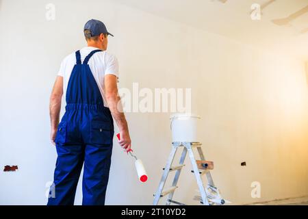 Professional home painter getting ready to paint a wall. Stock Photo
