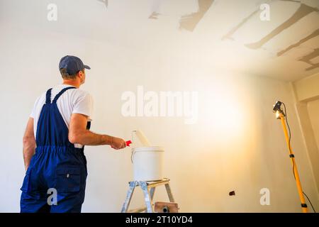 Professional home painter getting ready to paint a wall. Stock Photo