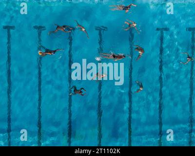 Aerial drone view shot of people competing in water polo in turquoise water pool Stock Photo