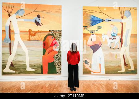 London, UK. 10th Oct, 2023. 'Tail End', 2021, (left) and 'The Darkward Trail', 2018 (right)- staff pose with the work. The Whitechapel Gallery presents 'What Happened', the first major UK retrospective of contemporary American artist Nicole Eisenman, with over 100 works on display, many of which have never been shown in the UK before. The exhibition runs until 14 Jan, 2024. Credit: Imageplotter/Alamy Live News Stock Photo