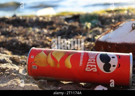 Dürres, Albania - 03 September 2022 : PRINGLES Original Flavor Potato Chips tube is laying on the beach, polluting the sea. Pollution control of the s Stock Photo