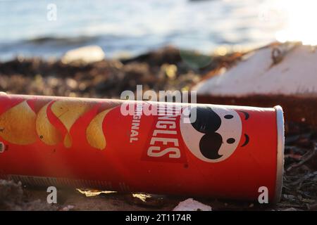 Dürres, Albania - 03 September 2022 : PRINGLES Original Flavor Potato Chips tube is laying on the beach, polluting the sea. Pollution control of the s Stock Photo