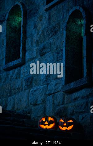 Halloween pumpkins jack p lanterns in the yard of an old castle at night in the bright moonlight Stock Photo