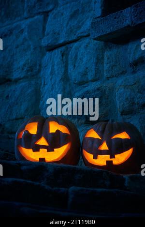 Halloween pumpkins jack p lanterns in the yard of an old castle at night in the bright moonlight Stock Photo