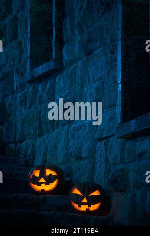 Halloween pumpkins jack p lanterns in the yard of an old castle at night in the bright moonlight Stock Photo