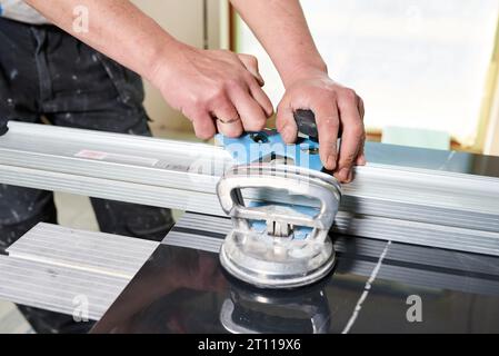 Construction worker cutting ceramic tiles using ceramic cutter Stock Photo