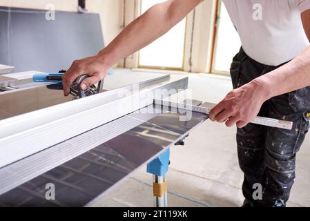 Construction worker cutting ceramic tiles using ceramic cutter Stock Photo