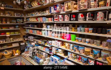 Gifts & souvenirs, post card, cards, mugs, pictures, displayed on display shelves & racks inside tourist souvenir visitor gift shop in Nice. France. (135) Stock Photo