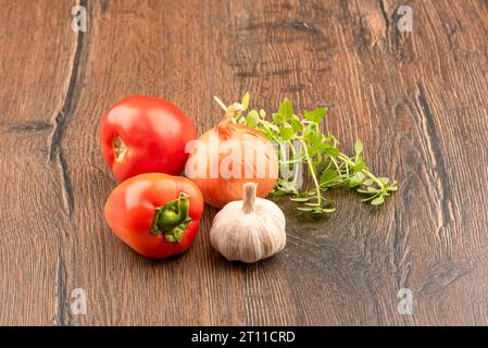 Garlic, onion, tomato, pepper and green basil on a wooden background. Copy space. Stock Photo