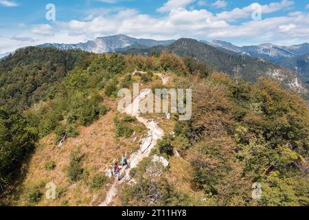 Aerial view of an active young couple, woman and man, hiking on the rocky mountain trail, directly above. Active vacation and adventure travel Stock Photo