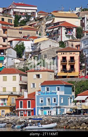 Colourful cliffside houses & restaurants look out onto picturesque Parga harbourfront, a coastal town in the Epirus region of northwest Greek mainland Stock Photo