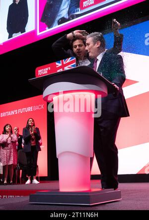 Glitter covers Keir Starmer.  The labour leader was covered by protester ,Yaz Ashmawi, during the start of the leaders speech.The protester was wrestled to ground and removed by security. Sir Keir Brushed his hair removed his jacket and carried on with speech. His shirt, hands and the floor around him was covered in glitter and remained so throughout the speech. His wife  Victoria Starmer applaued his speech throuout then joined him on stage at the end of the speech. Labour Conference 2023. Picture: garyroberts/worldwidefeatures.com Stock Photo