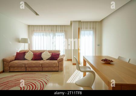 Living room with white sofa, dining table and Vitra Verner Panton chair Stock Photo