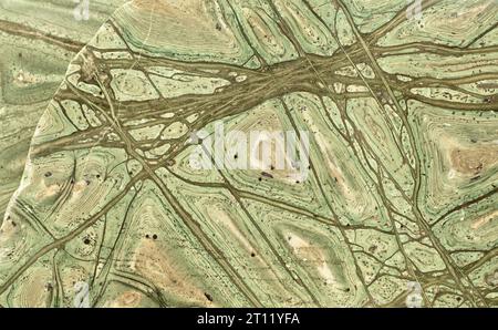 Surface of beautiful decorative stone, natural abstract pattern of green, brown and yellow stripes, lines, cracks, spots and stains Stock Photo