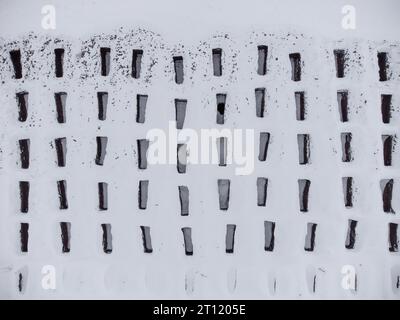Open empty graves among the snowy field, aerial drone view of emty tombs in the winter. Stock Photo