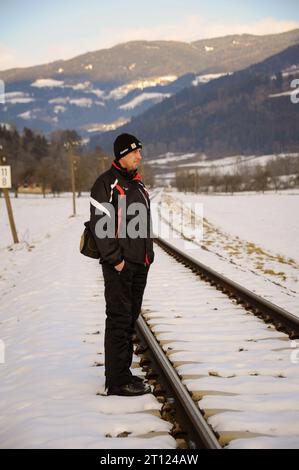 Mann spaziert im Schnee, Bahngleise Stock Photo
