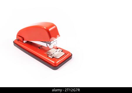 Detail of a red handheld stapler on a white background, copy and paste space Stock Photo