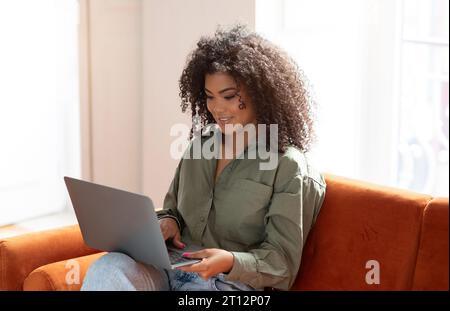 Smiling Black Bushy Woman Working On Laptop Computer A Home Stock Photo