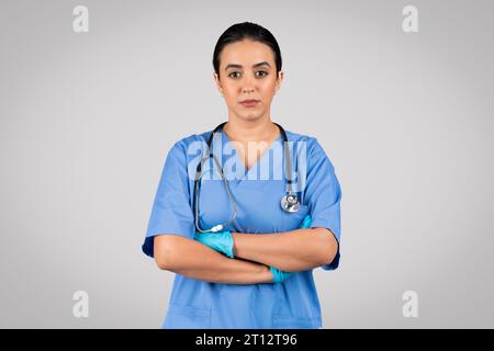 Confident female doctor in blue uniform posing with folded arms Stock Photo