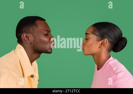 Side view of loving young black man and woman kissing Stock Photo