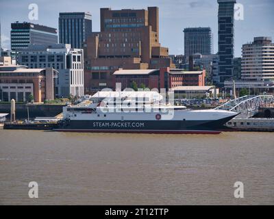 The Isle of Man ferry HSC Manannan moored at Liverpool on a sunny day with modern office and apartment buildings behind. Stock Photo