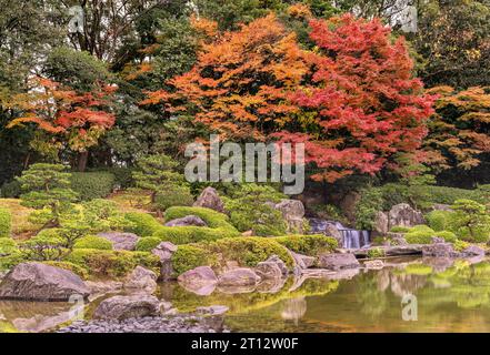 fukuoka, kyushu - dec 07 2022: Tranquil autumn scene in the Japanese Ohori garden where a waterfall tumbles gracefully into a placid pond Stock Photo