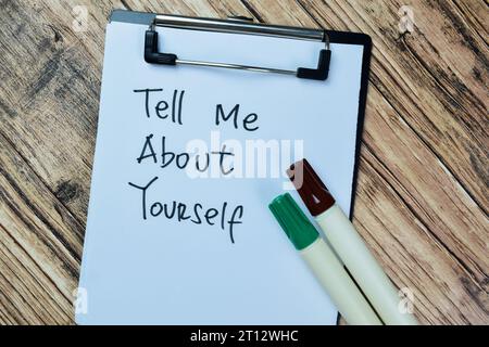 Concept of Tell Me About Yourself write on paperwork isolated on Wooden Table. Stock Photo