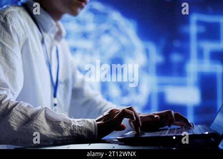 Computer operator in data center uses device for artificial intelligence computing simulating human brain through self learning algorithms. Tech support working with AI deep neural networks Stock Photo