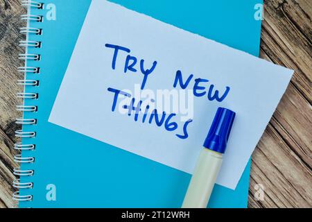 Concept of Try New Things write on sticky notes isolated on Wooden Table. Stock Photo