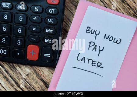 Concept of Buy Now Pay Later write on sticky notes isolated on Wooden Table. Stock Photo