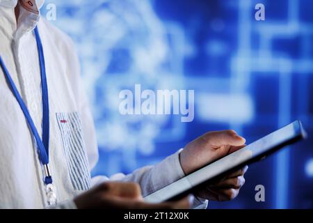 Computer scientist writes code on tablet to visualize artificial intelligence neural networks using augmented reality, close up. Server room professional runs AI script for information processing Stock Photo