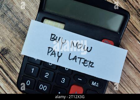 Concept of Buy Now Pay Later write on sticky notes isolated on Wooden Table. Stock Photo