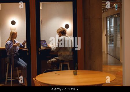 Two diverse business people working in modern coworking space Stock Photo