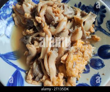mushrooms scrambled with eggs on the blue plate Stock Photo