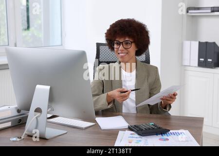Professional accountant having video chat via computer at desk in office Stock Photo