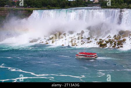 View of The Hornblower of Niagara City Cruises moving in front of The American Falls of Niagara Falls. Stock Photo