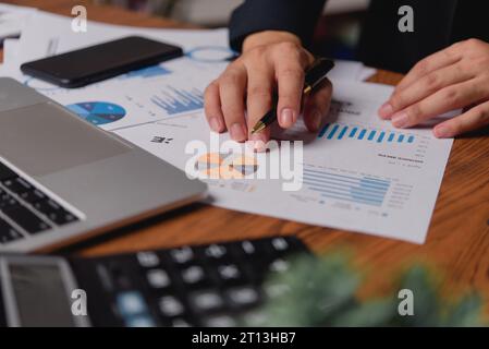 businessman working accountant document graph and chart on desk using calculator for calculate finance report in office. Stock Photo