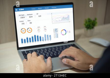 Man using computer laptop software with graphs and charts showing sales data. CRM Customer Relationship Management. Business Management Analysis Servi Stock Photo