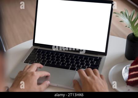 man using and typing on laptop computer mockup with blank screen. Stock Photo