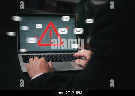 Man using laptop computer with hacker alarm protecting data from cybercrime in the digital age. Internet security and privacy defending against data t Stock Photo