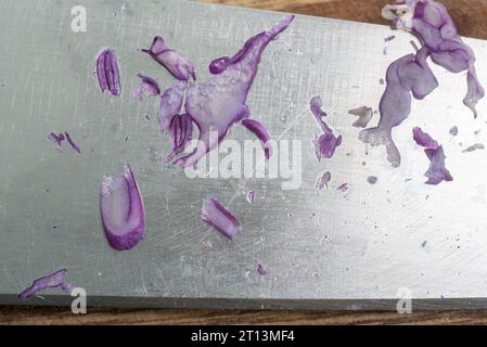 Residue of sliced purple cabbage on a kitchen knife. Stock Photo