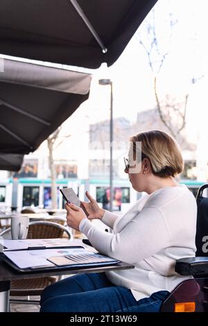 woman using wheelchair working with a tablet Stock Photo