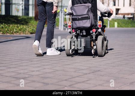 man walking with a person using wheelchair Stock Photo