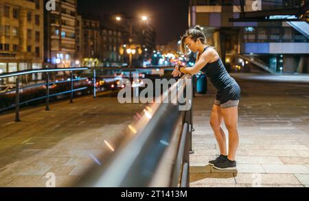 Young blonde runner woman checking exercise progress on smart watch application after training Stock Photo