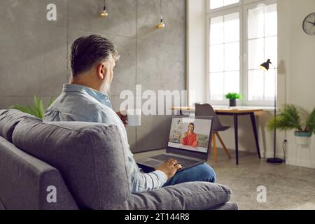 Gray haired bearded businessman talking with young woman using laptop Stock Photo
