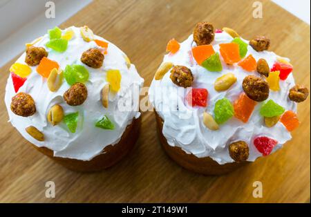 Easter cake, pie. Kulich, pie wrapped in paper. Easter cupcake with white glaze Stock Photo