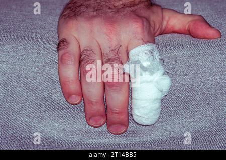 Male finger bandaged. Finger with a wound, injury. Close-up. Stock Photo