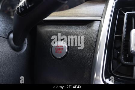 Car dashboard with focus on engine start stop button. Modern car interior details. start stop button. Car inside. Ignition remote starter Stock Photo