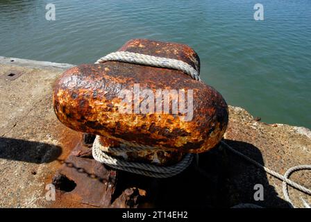 Large bollard with rope round it at end of concrete jetty, Whitstable, Kent Stock Photo